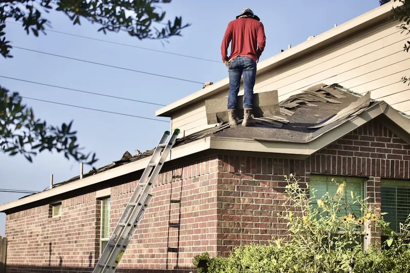 Professional roofer working on a residential roof in Linden